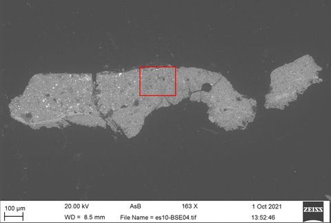 An image with a microscopic appearance, showing a detailed strand of rock or mineral spread out horizontally against a grey background. Along the lower band of the image are a series of numbers suggesting scientific study. On the right is the date 1 Oct 2021, along with a simple logo reading the word ‘Zeiss’.