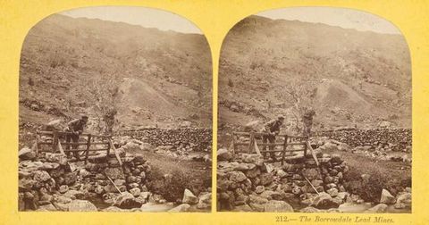 Colour photograph. A document of two nearly identical, sepia-tinted photographs, each showing a person leaning over a gate in a rocky landscape. The two photographs are arranged onto a pale-yellow backdrop, and each photo has an arched upper portion. Black ink printed onto the yellow ground reads, ‘212. – The Borrowdale Lead Mines’.